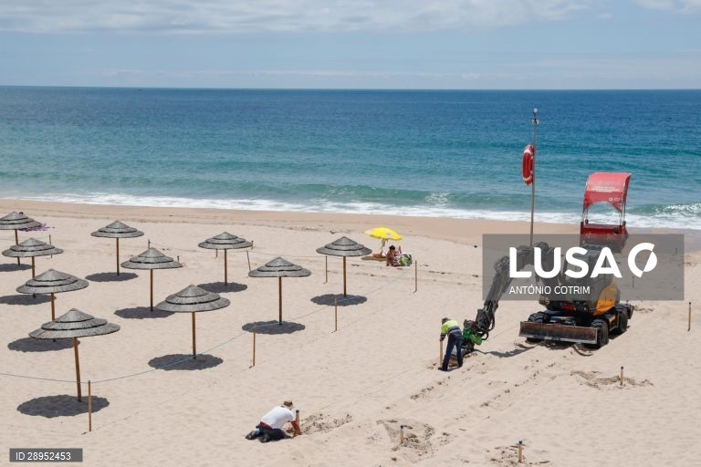 Trabalhadores colocam as estacas para definirem os corredores de circulação. Os concessionários da praia de Carcavelos em  Cascais, adaptam-se às novas imposições da Direção Geral da Saúde para o início da época balnear devido à pandemia provocada pela covid-19, Cascais, 04 de junho de 2020. Desde o dia 03 de maio que o país está em situação de calamidade, depois de três períodos consecutivos em estado de emergência desde 19 de março. (ACOMPANHA TEXTO DE DIA 5 DE JUNHO. ANTÓNIO COTRIM/LUSA