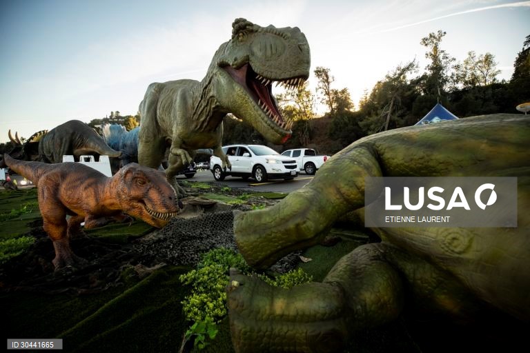 Visitantes passam por dinossauros animados em tamanho real na atracção Jurassic Quest no Rose Bowl em Pasadena, nordeste de Los Angeles, Califórnia, EUA.