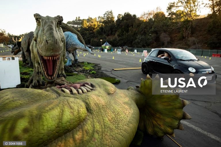 Visitantes passam por dinossauros animados em tamanho real na atracção Jurassic Quest no Rose Bowl em Pasadena, nordeste de Los Angeles, Califórnia, EUA.