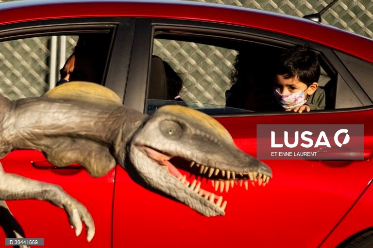 Visitantes passam por dinossauros animados em tamanho real na atracção Jurassic Quest no Rose Bowl em Pasadena, nordeste de Los Angeles, Califórnia, EUA.