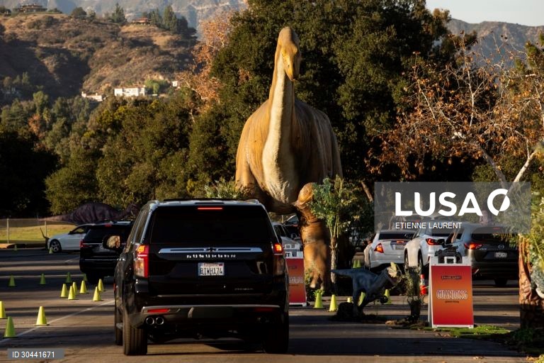 Visitantes passam por dinossauros animados em tamanho real na atracção Jurassic Quest no Rose Bowl em Pasadena, nordeste de Los Angeles, Califórnia, EUA.