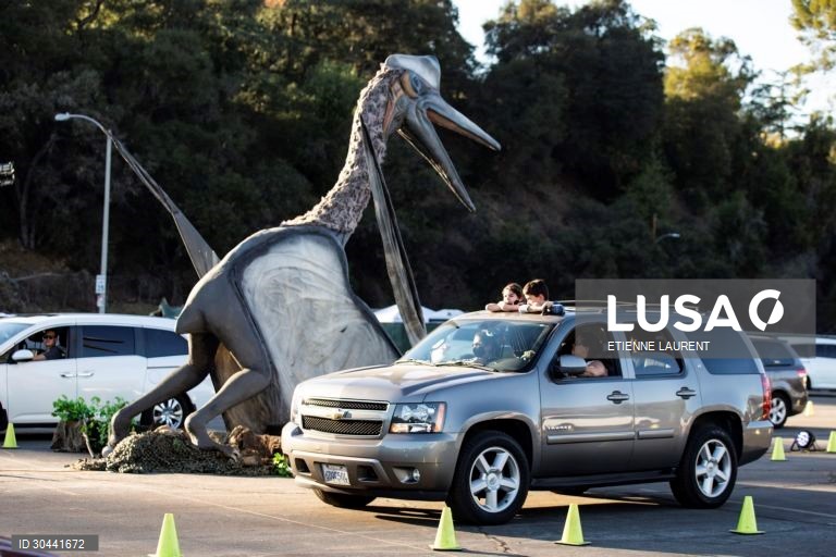 Visitantes passam por dinossauros animados em tamanho real na atracção Jurassic Quest no Rose Bowl em Pasadena, nordeste de Los Angeles, Califórnia, EUA.