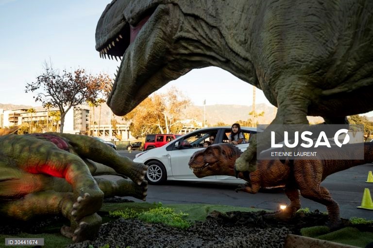 Visitantes passam por dinossauros animados em tamanho real na atracção Jurassic Quest no Rose Bowl em Pasadena, nordeste de Los Angeles, Califórnia, EUA.