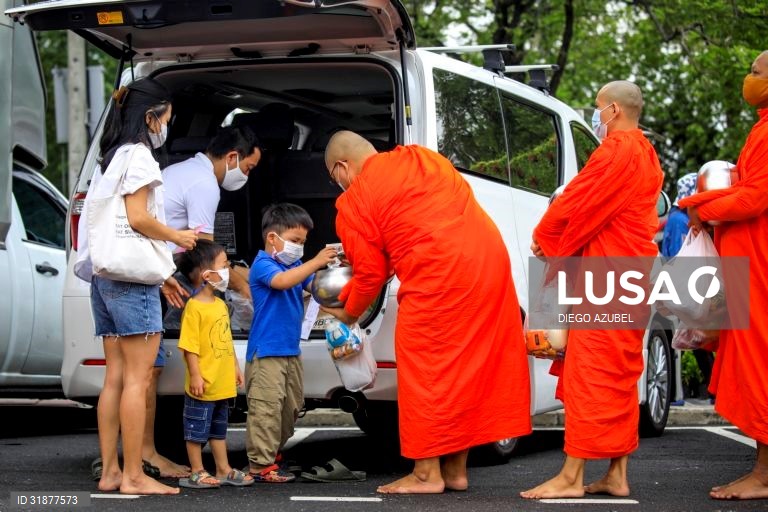 Monges budistas recebem esmolas na celebração do Visakha Bucha em Banguecoque