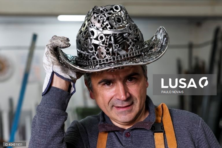 O serralheiro José António Antunes, com um chapéu que fez em ferro usando peças recolhidas em sucatas e oficinas, como rolamentos, carretos, porcas, correntes e molas, em Nandufe, Tondela, 13 de março de 2023. (ACOMPANHA TEXTO DE 19 DE MARÇO DE 2023). PAULO NOVAIS/LUSA