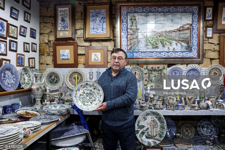 O artesão Carlos Tomás exibe prato de louça tradicional "ratinho" pintado à mão na sua loja no largo da Sé Velha, em Coimbra, 31 de outubro de 2023. O artesão de Coimbra reclama aos 69 anos o lugar de último pintor de louça 'ratinho', ligada aos antigos movimentos migratórios dos camponeses do Centro e do Norte para os trabalhos agrícolas sazonais do Sul. (ACOMPANHA TEXTO DA LUSA DO DIA 11 DE NOVEMBRO DE 2023). PAULO NOVAIS/LUSA