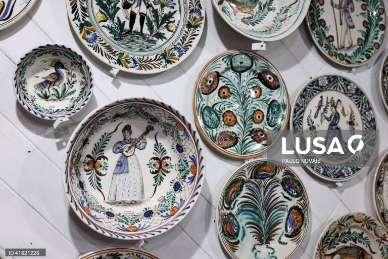 Pratos de louça tradicional "ratinho" pintado à mão pelo artesão Carlos Tomás (ausente da fotografia) na sua loja no largo da Sé Velha, em Coimbra, 31 de outubro de 2023. O artesão de Coimbra reclama aos 69 anos o lugar de último pintor de louça 'ratinho', ligada aos antigos movimentos migratórios dos camponeses do Centro e do Norte para os trabalhos agrícolas sazonais do Sul. (ACOMPANHA TEXTO DA LUSA DO DIA 11 DE NOVEMBRO DE 2023). PAULO NOVAIS/LUSA