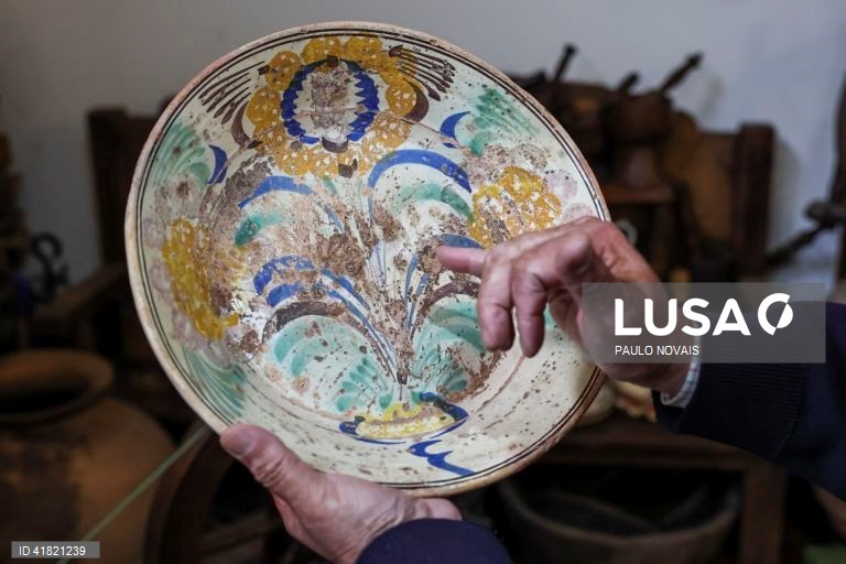 O investigador Aires Henriques examina um dos quase 100 pratos de louça tradicional "ratinho" que reúne no Solar do Povo Ratinho, em Pedrógão Grande, 31 de outubro de 2023. O tipo de louça "ratinho" está ligada aos antigos movimentos migratórios dos camponeses do Centro e do Norte para os trabalhos agrícolas sazonais do Sul. (ACOMPANHA TEXTO DA LUSA DO DIA 11 DE NOVEMBRO DE 2023). PAULO NOVAIS/LUSA