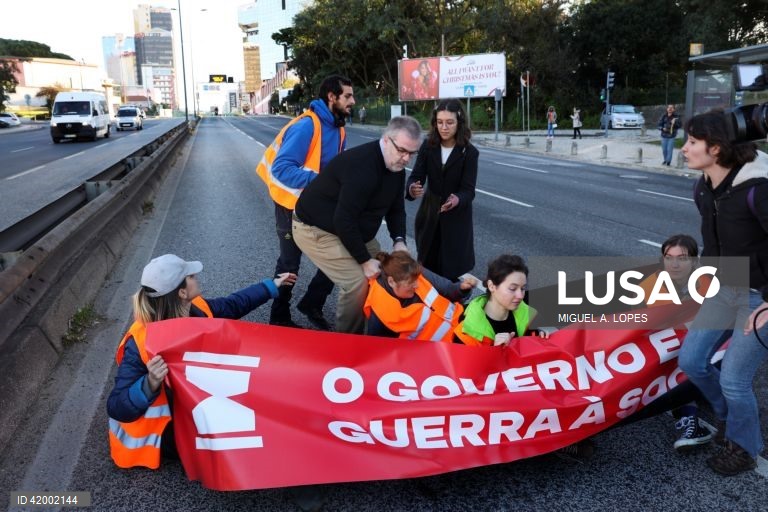 Populares tentam retirar os ativistas da Climáximo que bloqueiam o acesso a Lisboa pela A5 durante uma ação de protesto, 14 de dezembro de 2023. MIGUEL A. LOPES/LUSA