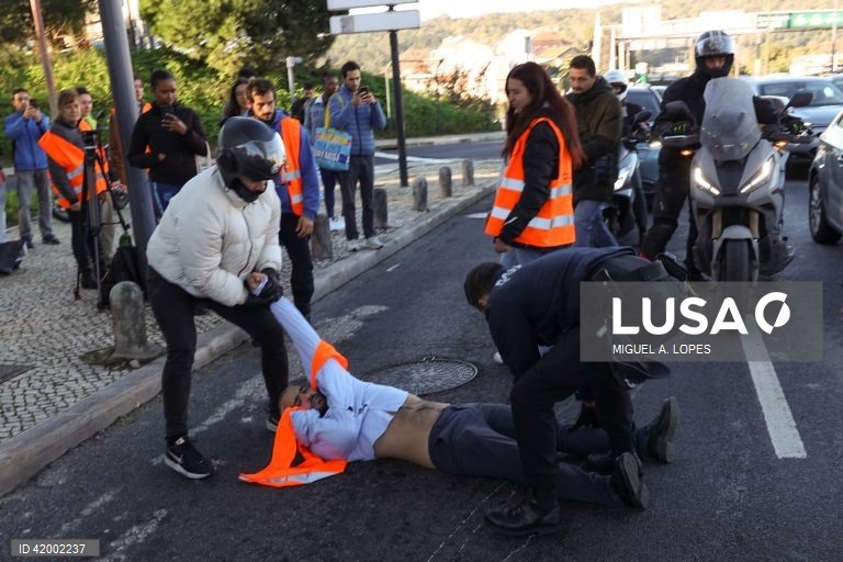 Agentes da Polícia e populares retiram ativistas da Climáximo que bloqueiam o acesso a Lisboa pela A5 durante uma ação de protesto, 14 de dezembro de 2023. MIGUEL A. LOPES/LUSA