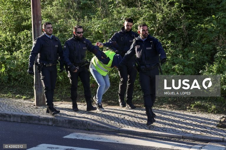Agentes da Polícia detêm um ativista da Climáximo que bloqueiam o acesso a Lisboa pela A5 durante uma ação de protesto, 14 de dezembro de 2023. MIGUEL A. LOPES/LUSA