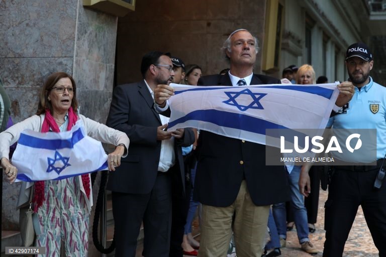 Participantes no evento “76.º Dia da Independência” promovido pela Embaixada de Israel seguram bandeiras de Israel defronte do cinema São Jorge, Lisboa, 22 de maio de 2024. Este evento sofreu uma ação de protesto convocada pela Plataforma Unitária em Solidariedade com a Palestina.  MANUEL DE ALMEIDA/LUSA