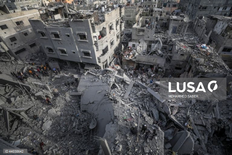 Palestinianos inspeccionam os escombros de edifícios destruídos na sequência de ataques aéreos israelitas no campo de refugiados de Al Nuseirat, no centro da Faixa de Gaza.