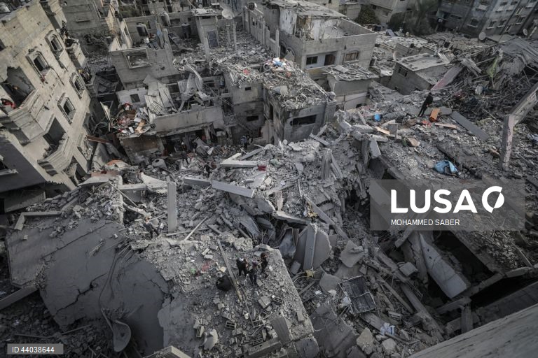 Palestinianos inspeccionam os escombros de edifícios destruídos na sequência de ataques aéreos israelitas no campo de refugiados de Al Nuseirat, no centro da Faixa de Gaza.