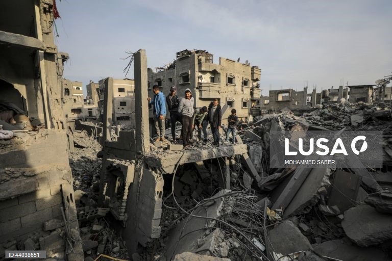 Palestinianos inspeccionam os escombros de edifícios destruídos na sequência de ataques aéreos israelitas no campo de refugiados de Al Nuseirat, no centro da Faixa de Gaza.