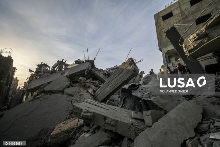 Palestinianos inspeccionam os escombros de edifícios destruídos na sequência de ataques aéreos israelitas no campo de refugiados de Al Nuseirat, no centro da Faixa de Gaza.