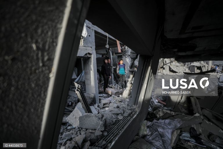 Palestinianos inspeccionam os escombros de edifícios destruídos na sequência de ataques aéreos israelitas no campo de refugiados de Al Nuseirat, no centro da Faixa de Gaza.