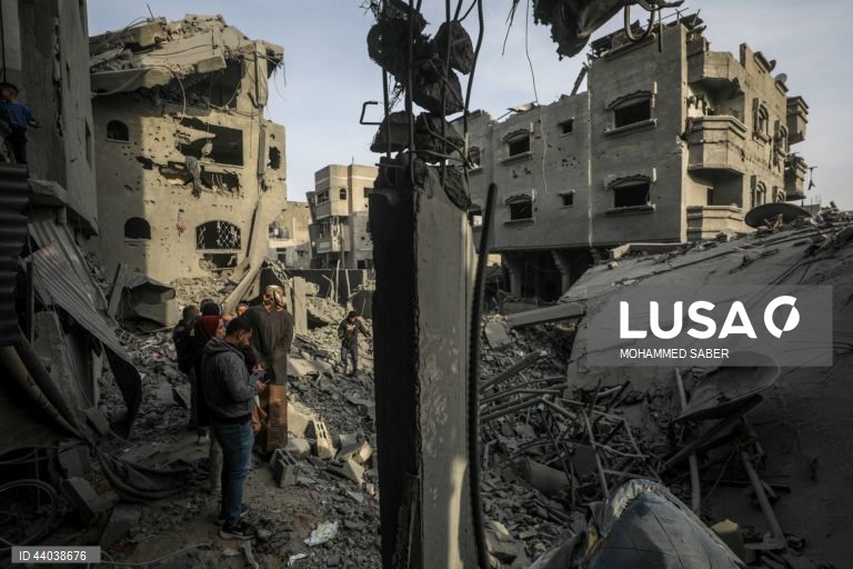 Palestinianos inspeccionam os escombros de edifícios destruídos na sequência de ataques aéreos israelitas no campo de refugiados de Al Nuseirat, no centro da Faixa de Gaza.