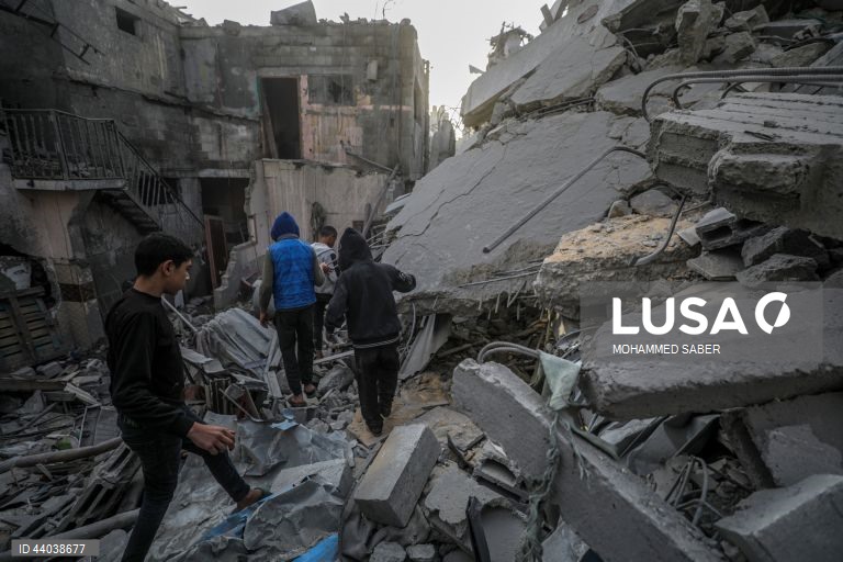 Palestinianos inspeccionam os escombros de edifícios destruídos na sequência de ataques aéreos israelitas no campo de refugiados de Al Nuseirat, no centro da Faixa de Gaza.
