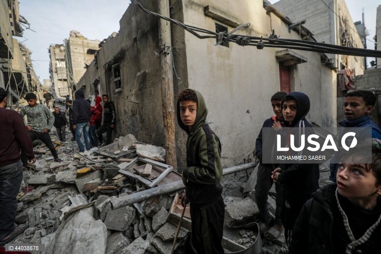 Palestinianos inspeccionam os escombros de edifícios destruídos na sequência de ataques aéreos israelitas no campo de refugiados de Al Nuseirat, no centro da Faixa de Gaza.