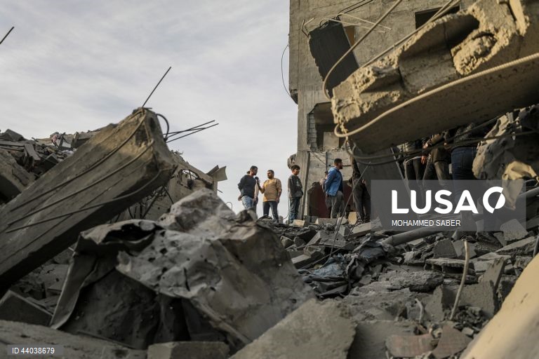 Palestinianos inspeccionam os escombros de edifícios destruídos na sequência de ataques aéreos israelitas no campo de refugiados de Al Nuseirat, no centro da Faixa de Gaza.