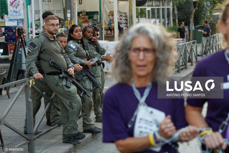 Militares israelitas assistem ao protesto de mães de reféns e soldados em frente à casa do primeiro-ministro Benjamin Netanyahu, acorrentando-se e transportando três caixões vazios, em Jerusalém, Israel, 18 de setembro de 2025. Os três caixões simbolizam o próximo refém que será assassinado devido à pressão militar, o segundo para o seguinte refém falecido devido aos bombardeamentos das Forças de Defesa de Israel (IDF) e o terceiro para o próximo soldado que morrerá na "guerra sem sentido" em...
