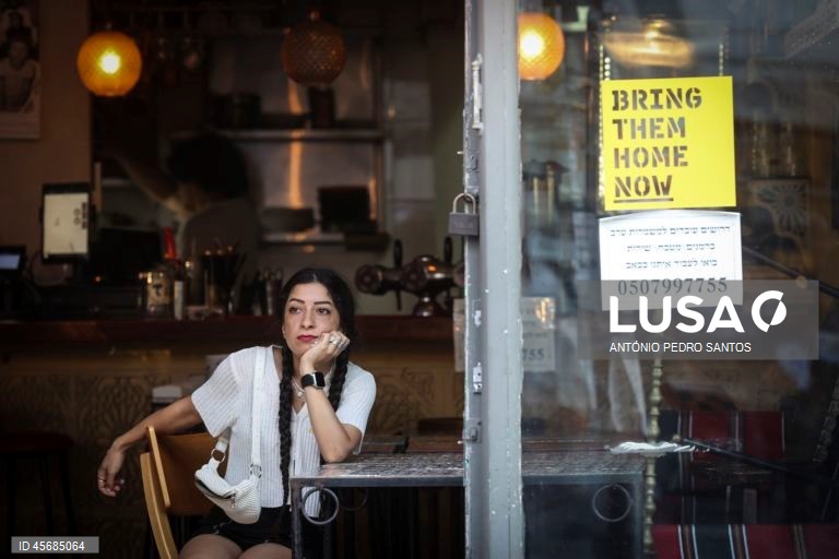 Uma mulher assiste ao protesto de mães de reféns e soldados israelitas em frente à casa do primeiro-ministro Benjamin Netanyahu, acorrentando-se e transportando três caixões vazios, em Jerusalém, Israel, 18 de setembro de 2025. Os três caixões simbolizam o próximo refém que será assassinado devido à pressão militar, o segundo para o seguinte refém falecido devido aos bombardeamentos das Forças de Defesa de Israel (IDF) e o terceiro para o próximo soldado que morrerá na "guerra sem sentido" em...