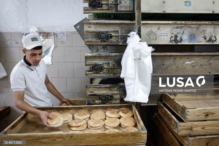 Um homem arruma pão num tabuleiro no centro da cidade de Ramallah, Cisjordânia, 23 de setembro de 2025. ANTÓNIO PEDRO SANTOS/LUSA

