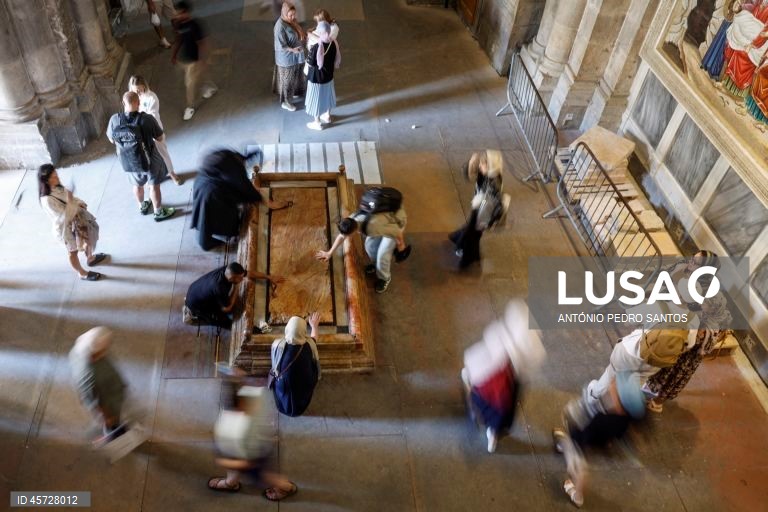 Um grupo de pessoas reza junto à sepultura de Jesus Cristo na Basílica do Santo Sepulcro, local sagrado onde se acredita que foi crucificado, sepultado e ressuscitou, em Jerusalém, Israel, 26 de setembro de 2025. Construída no século IV sob as ordens do imperador Constantino, a igreja circunda o local onde o corpo de Jesus teria sido colocado após a crucificação. ANTÓNIO PEDRO SANTOS/LUSA