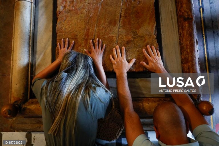 Um casal reza junto à sepultura de Jesus Cristo, na Basílica do Santo Sepulcro, local sagrado onde se acredita que foi crucificado, sepultado e ressuscitou, em Jerusalém, Israel, 26 de setembro de 2025. Construída no século IV sob as ordens do imperador Constantino, a igreja circunda o local onde o corpo de Jesus teria sido colocado após a crucificação. ANTÓNIO PEDRO SANTOS/LUSA