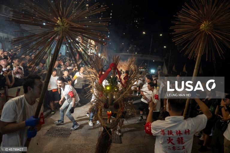 Fiéis carregam um dragão coberto de incensos acesos pelas ruas durante o desfile do dragão de fogo na vila de Pok Fu Lam, Hong Kong, China. A dança anual, realizada durante o Festival do Meio Outono, é realizada para rezar por saúde e boa sorte. 