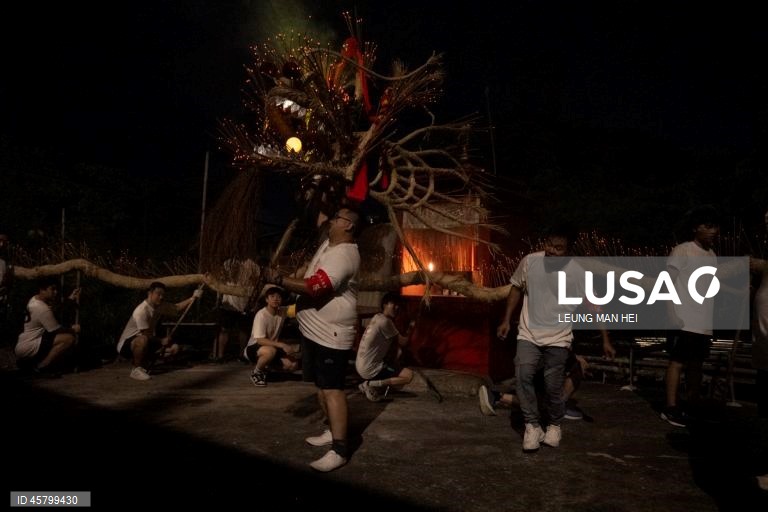 Fiéis carregam um dragão coberto de incensos acesos pelas ruas durante o desfile do dragão de fogo na vila de Pok Fu Lam, Hong Kong, China. A dança anual, realizada durante o Festival do Meio Outono, é realizada para rezar por saúde e boa sorte. 