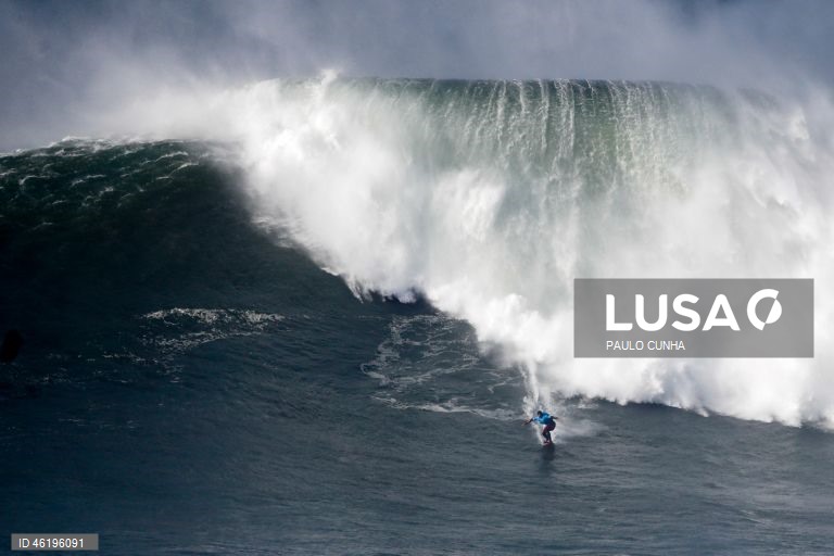 Um surfista compete durante a prova no Nazaré Big Wave Challenge, prova que anualmente reúne algumas das maiores estrelas do surf de ondas grandes, na Praia do Norte, 13 de dezembro de 2025. Centenas de pessoas estão reunidas no Forte de São Miguel Arcanjo, na Nazaré, para ver as ondas gigantes e os surfistas que as vão desafiar. PAULO CUNHA/LUSA