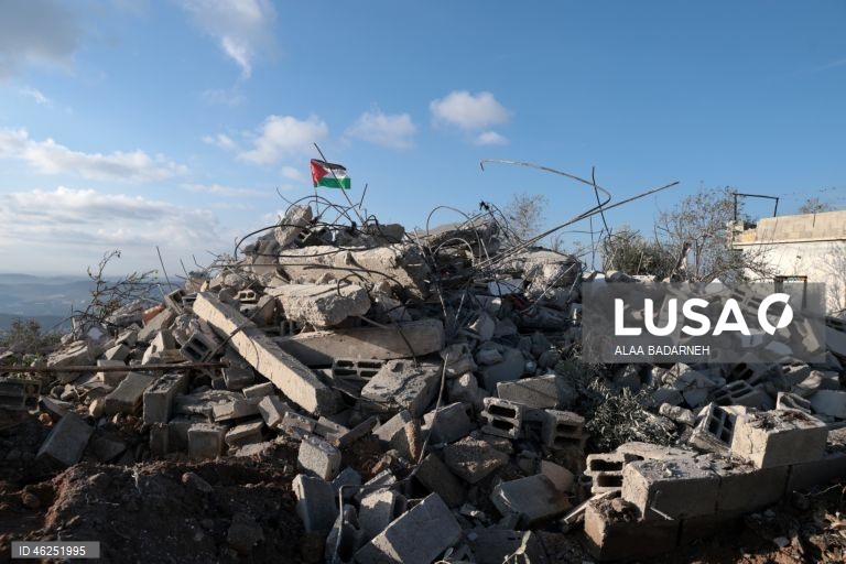 Um menino palestiniano agita uma bandeira palestiniana sobre os escombros da casa pertencente à família de Malik Ismail Salem na aldeia de Bizarya, perto da cidade de Nablus, na Cisjordânia. O exército israelita demoliu a casa de Malik Ismail Salem, que foi morto por tiros israelitas em 10 de julho de 2025, de acordo com a agência de notícias palestiniana WAFA.