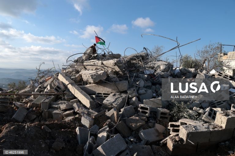 Um menino palestiniano agita uma bandeira palestiniana sobre os escombros da casa pertencente à família de Malik Ismail Salem na aldeia de Bizarya, perto da cidade de Nablus, na Cisjordânia. O exército israelita demoliu a casa de Malik Ismail Salem, que foi morto por tiros israelitas em 10 de julho de 2025, de acordo com a agência de notícias palestiniana WAFA.