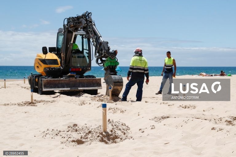 Trabalhadores colocam as estacas para definirem os corredores de circulação. Os concessionários da praia de Carcavelos em  Cascais, adaptam-se às novas imposições da Direção Geral da Saúde para o início da época balnear devido à pandemia provocada pela covid-19, Cascais, 04 de junho de 2020. Desde o dia 03 de maio que o país está em situação de calamidade, depois de três períodos consecutivos em estado de emergência desde 19 de março. (ACOMPANHA TEXTO DE DIA 5 DE JUNHO. ANTÓNIO COTRIM/LUSA