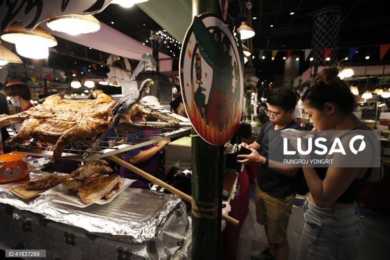 Vendedores de comida tailandesa vendem carne de crocodilo grelhada no mercado de rua em Banguecoque, Tailândia. A carne de crocodilo tem sido considerada uma carne nutricional altamente saudável, com menos gordura, baixo teor de colesterol e maior teor de proteínas do que a carne de porco ou de frango, com benefícios para a saúde do coração e para a circulação sanguínea.