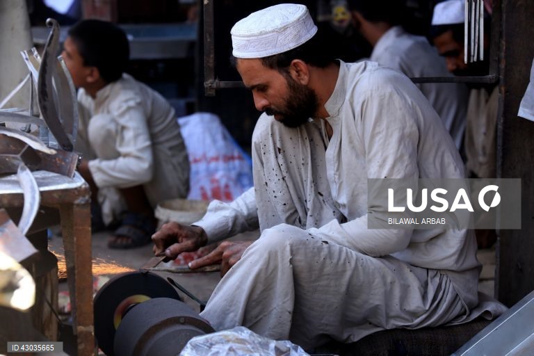 Um ferreiro afia facas antes da festa muçulmana de Eid al-Adha em Peshawar, Paquistão, O Eid al-Adha é um dos feriados muçulmanos mais sagrados do ano. Assinala a peregrinação anual dos muçulmanos, conhecida por Hajj, a Meca. Durante o Eid al-Adha, os muçulmanos abatem cabras, ovelhas e gado bovino para comemorar a disponibilidade do Profeta Abraão para sacrificar o seu filho em sinal de obediência a Deus. A carne é dividida em três partes: uma para a família, outra para os amigos e parentes e...