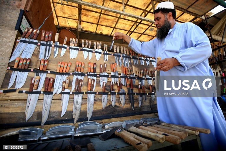 Um ferreiro afia facas antes da festa muçulmana de Eid al-Adha em Peshawar, Paquistão, O Eid al-Adha é um dos feriados muçulmanos mais sagrados do ano. Assinala a peregrinação anual dos muçulmanos, conhecida por Hajj, a Meca. Durante o Eid al-Adha, os muçulmanos abatem cabras, ovelhas e gado bovino para comemorar a disponibilidade do Profeta Abraão para sacrificar o seu filho em sinal de obediência a Deus. A carne é dividida em três partes: uma para a família, outra para os amigos e parentes e...