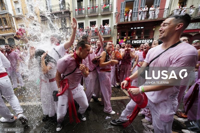 Pessoas festejam após o disparo do "chupinazo", que marca o início da festa de San Fermin em Pamplona, Espanha. A festa de San Fermin 2024 decorre de 6 a 14 de julho, com a corrida de touros como evento principal.