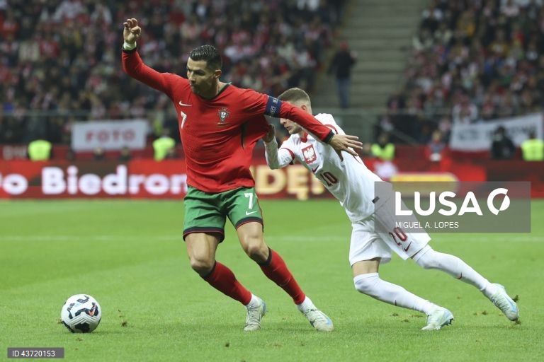 O jogador da seleção da Polónia Sebastian Szymanski (D), disputa a bola com o jogador da seleção de Portugal Cristiano Ronaldo (E), durante o jogo da Fase de Grupos - Grupo 1 - da Liga das Nações da UEFA, Polónia vs Portugal, no Estádio Narodowy, em Varsóvia, Polónia, 12 de outubro de 2024. MIGUEL A. LOPES/LUSA