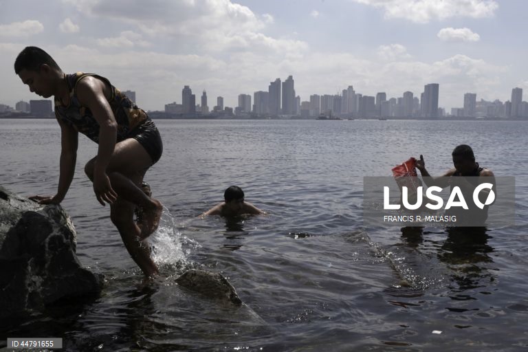 Filipinas: populares refrescam-se e divertem-se nas águas poluídas da Baía de Manila no dia de São Domingos