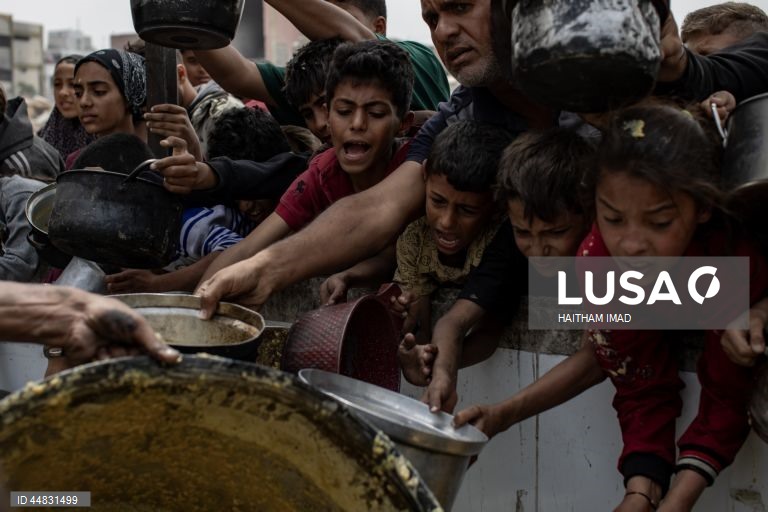 Palestinianos deslocados recolhem alimentos doados em Jabalia, no norte de Gaza