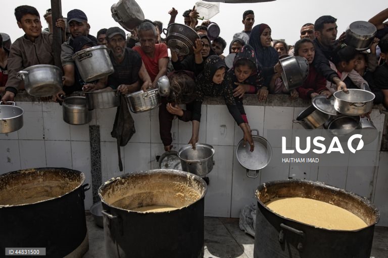 Palestinianos deslocados recolhem alimentos doados em Jabalia, no norte de Gaza