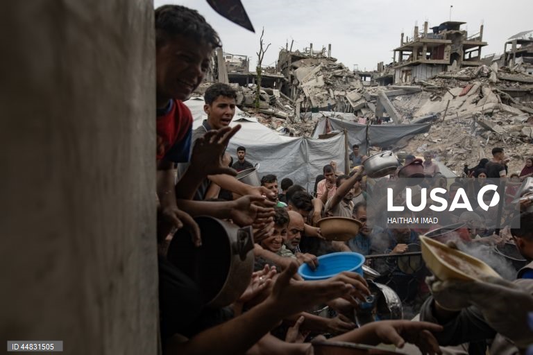Palestinianos deslocados recolhem alimentos doados em Jabalia, no norte de Gaza