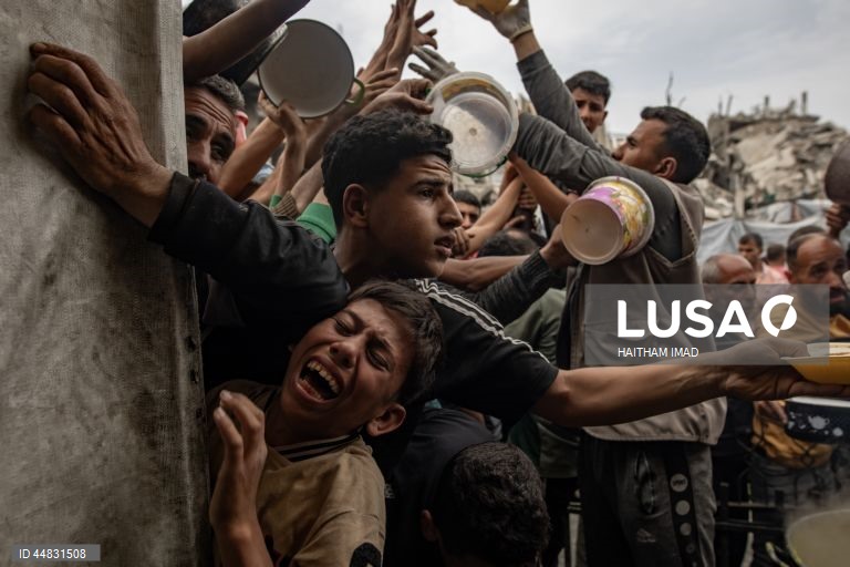 Palestinianos deslocados recolhem alimentos doados em Jabalia, no norte de Gaza