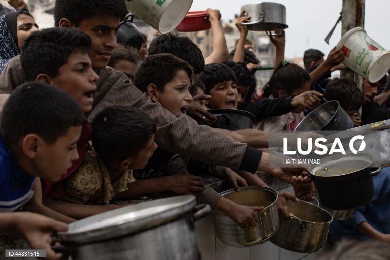 Palestinianos deslocados recolhem alimentos doados em Jabalia, no norte de Gaza