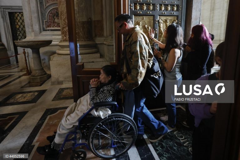 Fiéis passam a porta santa da Basílica de São Pedro