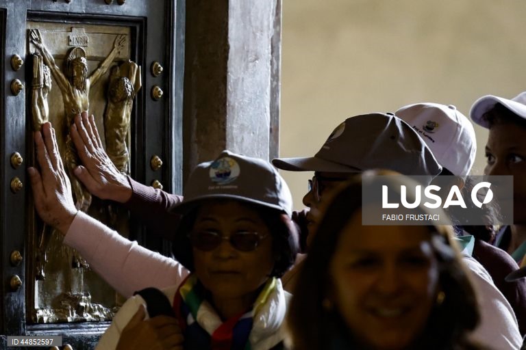 Fiéis passam a porta santa da Basílica de São Pedro