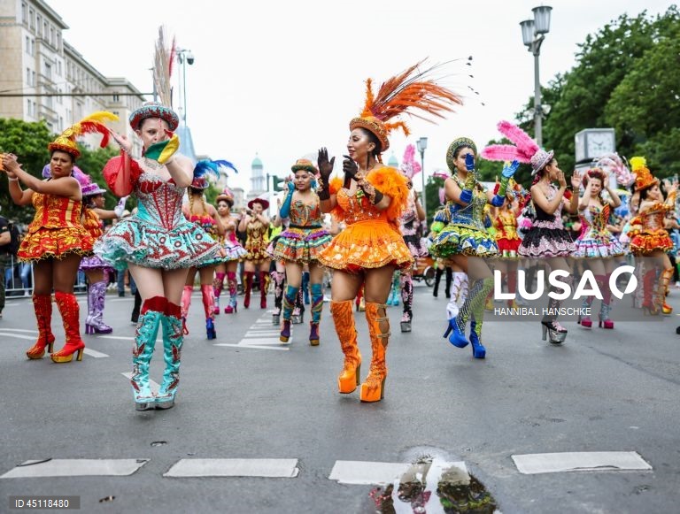 Pessoas vestem trajes tradicionais enquanto participam no Carnaval das Culturas em Berlim, Alemanha. O desfile envolve mais de 4 000 participantes que exibem as culturas dos seus países de origem. O Carnaval das Culturas é celebrado anualmente em Berlim desde 1996 e pretende ser um símbolo da diversidade e da coexistência pacífica. 